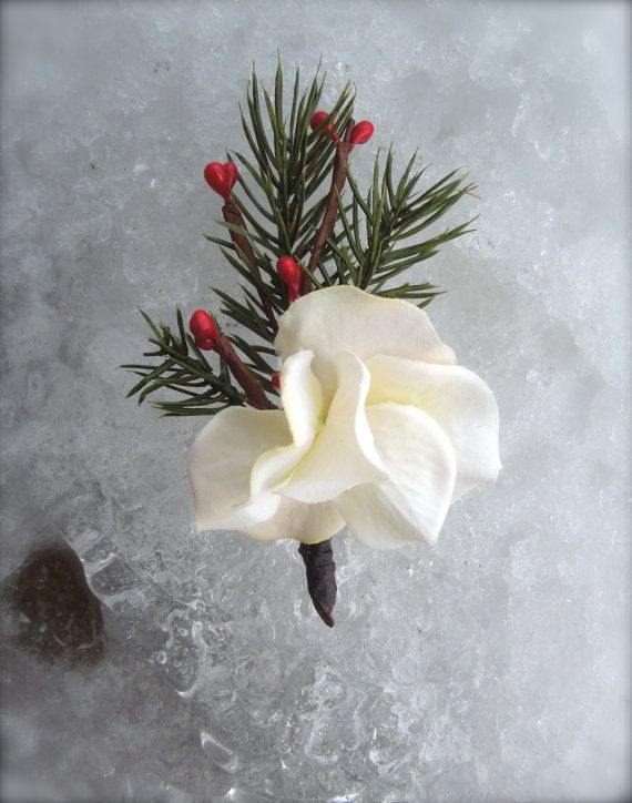 A winter wedding boutonniere of a white bloom, berries and fir branches is a cool and simple idea