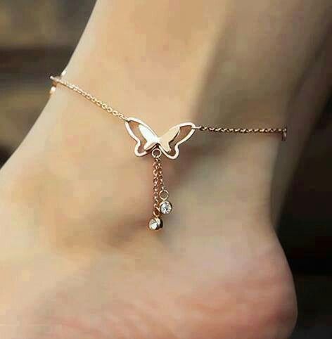 a delicate gold chain anklet with a butterfly and rhinestones hanging down is a stylish addition to a summer bridal look