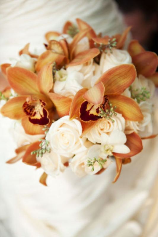A lush fall wedding bouquet of white roses and amber lilies is a stylish and refined idea for a fall bride