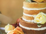 a naked wedding cake decorated with berries and amber and copper roses is great for a fall wedding