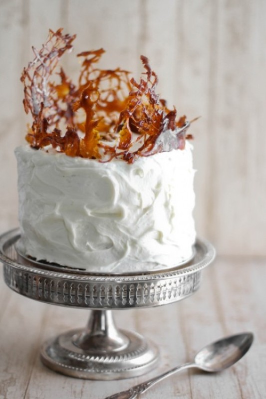 A white buttercream wedding cake with amber caramel shards on top is a very creative and cool idea for a modern fall wedding