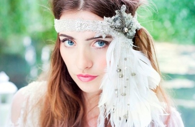 A lace and rhinestone headpiece with a fabric bow with a pearl and long feathers down for a wild boho look