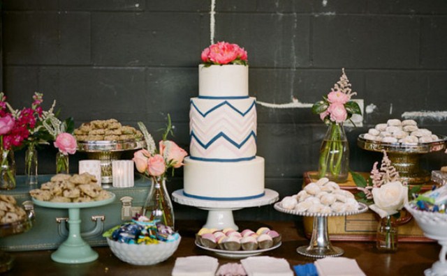 A white navy and blush chevron wedding cake with bold coral blooms on top is ideal for a mid century modern or boho wedding