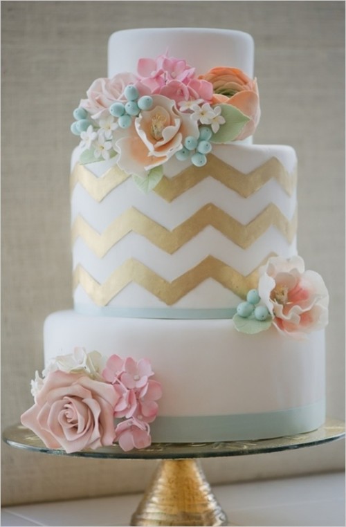 a white, mint and gold chevron wedding cake with pastel blooms and berries is a lovely idea for a spring or summer wedding