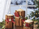 candles covered with cinnamon sticks, with faux berries, ribbons and mini bells is a very cozy and rustic idea