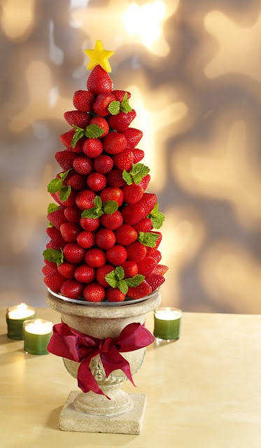 a pretty edible Christmas wedding centerpiece of a Christmas tree made of strawberries and mint and placed into a porcelain bowl