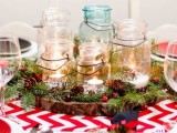 a rustic Christmas wedding centerpiece of a wood slice, ir, pinecones and jars with candles is very cute