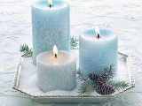 a simple Christmas wedding centerpiece of a geometric tray with faux snow, pinecones and blue snowy candles is a very beautiful idea