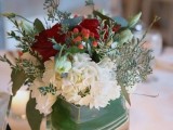 a chic and elegant Christmas wedding centerpiece of white, burgundy blooms and greenery is a stylish decoration