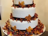 a fall wedding cake with brown ribbons, berries and leaves is a stylish and timeless idea for the fall