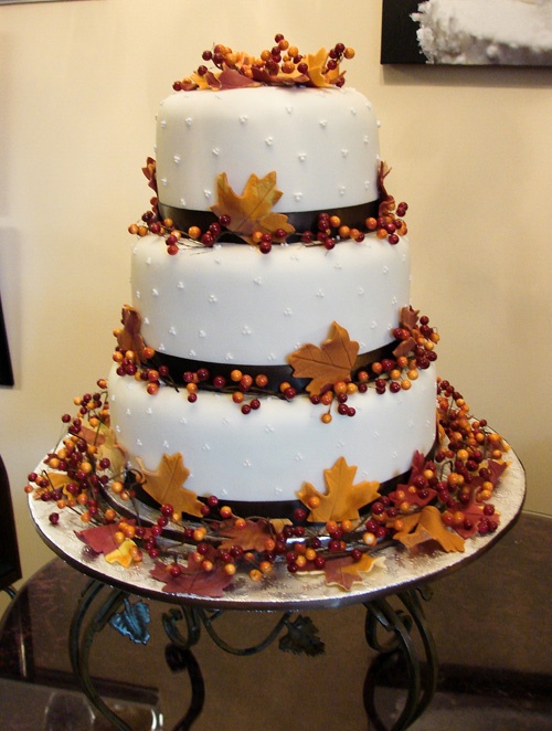a fall wedding cake with brown ribbons, berries and leaves is a stylish and timeless idea for the fall