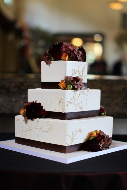 a chic square fall wedding cake decorated with brown ribbons and moody fall blooms plus white patterns