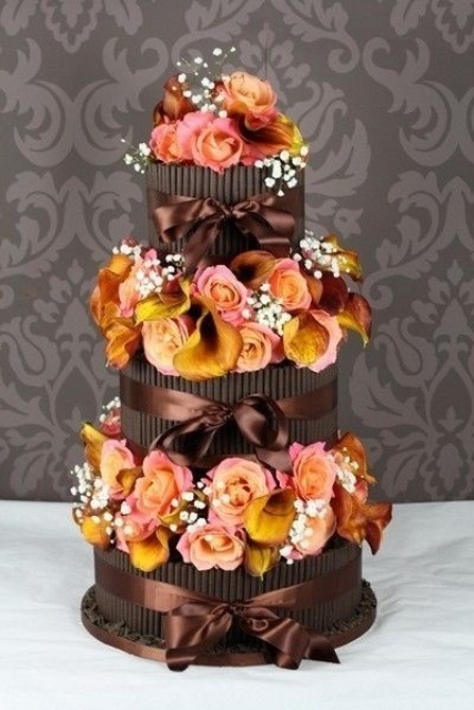 a chocolate fall wedding cake decorated with fresh fall blooms and baby's breath for a bold contrast