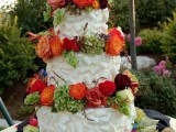 a white chocolate wedding cake decorated fresh blooms in fall colors looks really unusual