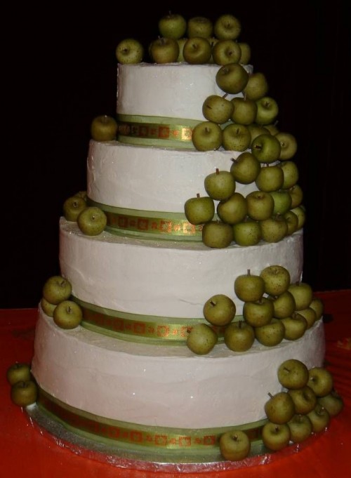 a large fall wedding cake decorated with small green apples feels and looks really fall-like