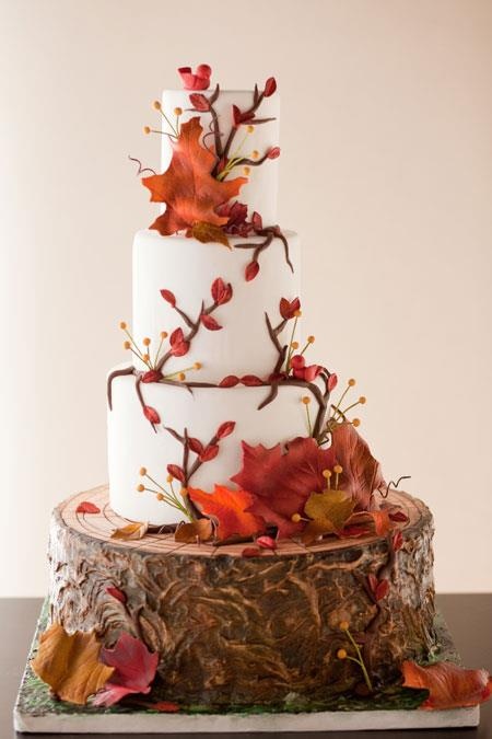 a fall wedding cake with sugar blooms, twigs and berries in bold colors for a bright fall wedding