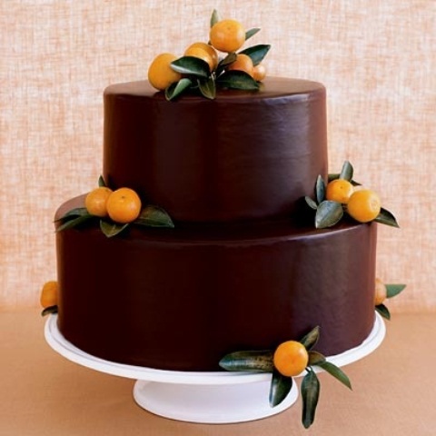 a chocolate wedding cake decorated with leaves and citrus is great for the fall