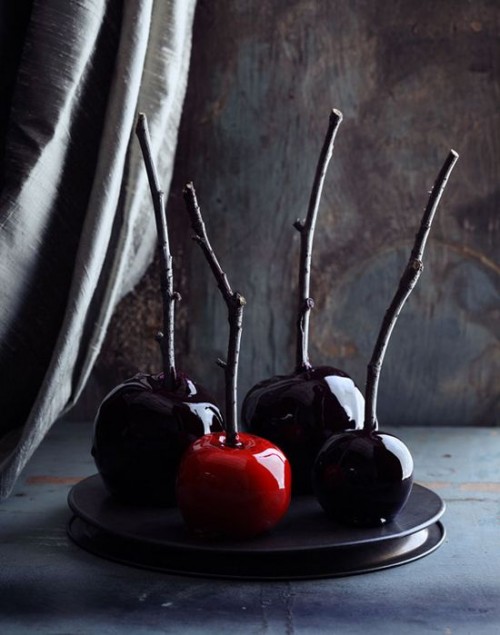 candied red and deep purple apples on sticks are delicious Halloween wedding favors that your guests may enjoy