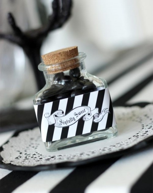 a bottle with black candies and a striped sticker is a cool and creative Halloween wedding favor idea to make yourself