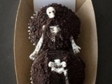 a box with two cupcakes as a grave and a skeleton on top is a creative and unusual Halloween wedding favor