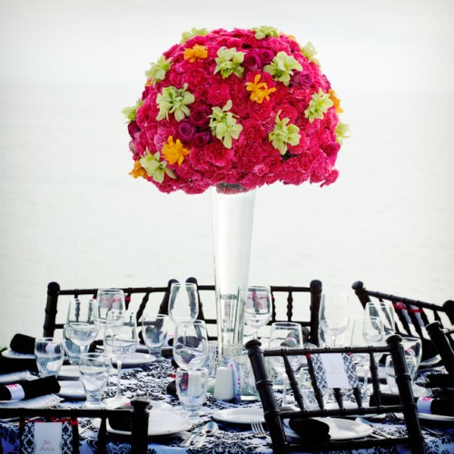 a black and white tablescape with patterns and a bright floral centerpiece for a colorful touch