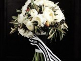 a black and white wedding bouquet with berries and striped ribbons