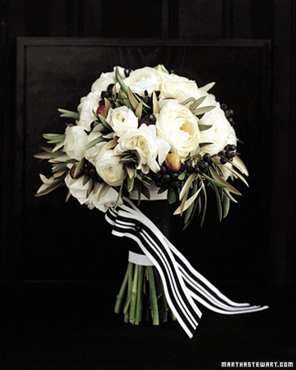 A black and white wedding bouquet with berries and striped ribbons