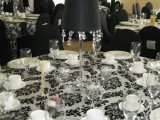 a black and white patterned tablecloth, a black lamp with crystals for decor