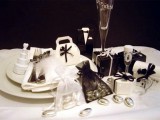 a black and white wedding favor table with glasses and bows is elegance