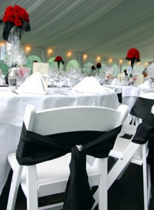 a white tablescape, white chairs and a black bow on the chair