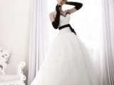 a princess-style wedding gown with black gloves and a black sash