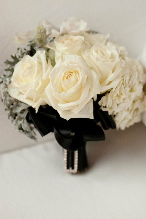 a white rose wedding bouquet with pale millet and black bows