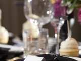 black and white plates, black napkins, gilded cutlery
