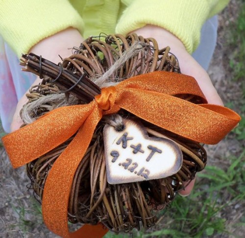 a vine pumpkin with rust ribbons and a burnt wooden heart tag to decorate your wedding venue