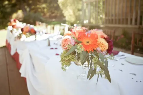 a bright fall floral wedding centerpiece with foliage is a cute idea for a fall wedding