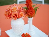 a bright fall floral centerpiece with touches of foliage and white porcelain