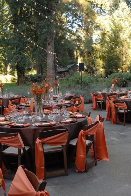 an outdoor reception space done in chocolate brown and rust, with rust-colored centerpieces and bright napkins