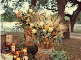 beautiful fall wedding decor with an arrangement of blooms, wheat and foliage plus moss