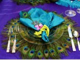 a bright wedding place setting done with a turquoise napkin and a peacock feather charger