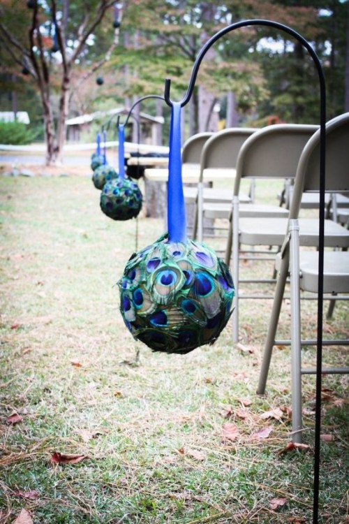a peacock ball with a bright blue ribbon is a creative idea to accent a wedding aisle