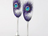 wedding flutes decorated with purple peacock feathers painted on them