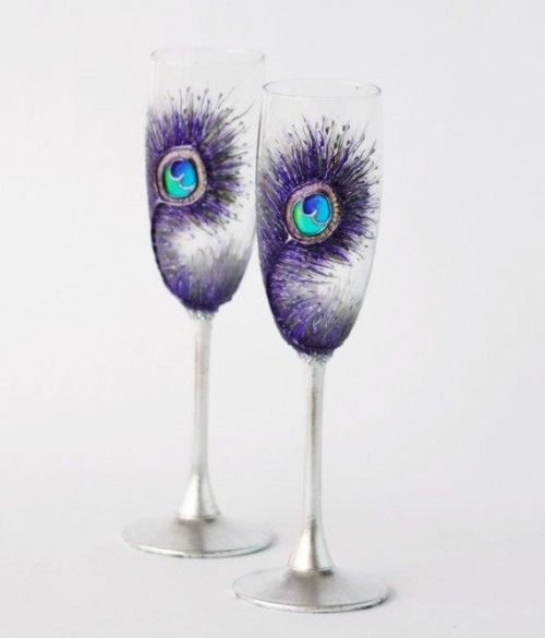 wedding flutes decorated with purple peacock feathers painted on them