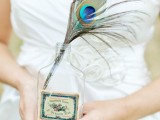 a simple wedding decoration of a peacock feather placed in a bottle