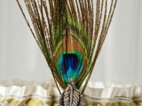 a wedding garter with a peacock feather and a vintage brooch is a unique accessory