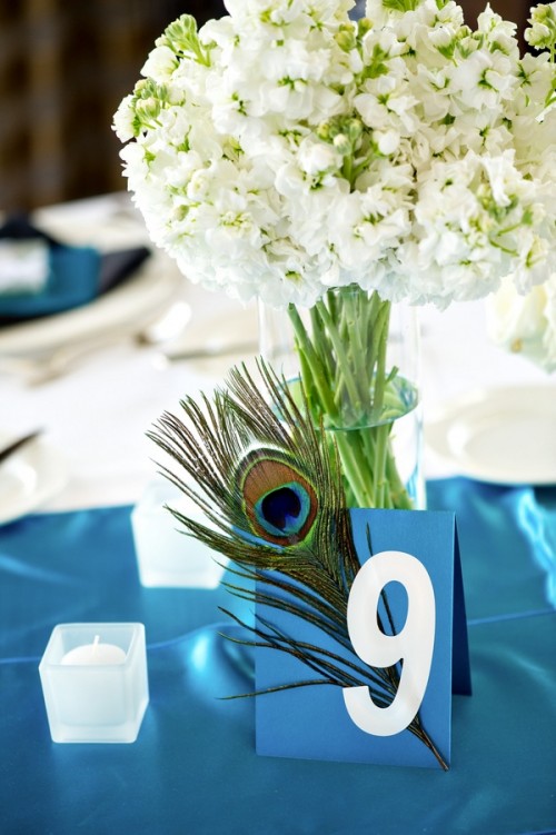 a wedding table number - a blue card with a peacock feather for an accent and better visibility
