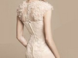 a romantic blush sheath short wedding dress of lace, with cap sleeves and feathers for a cute touch