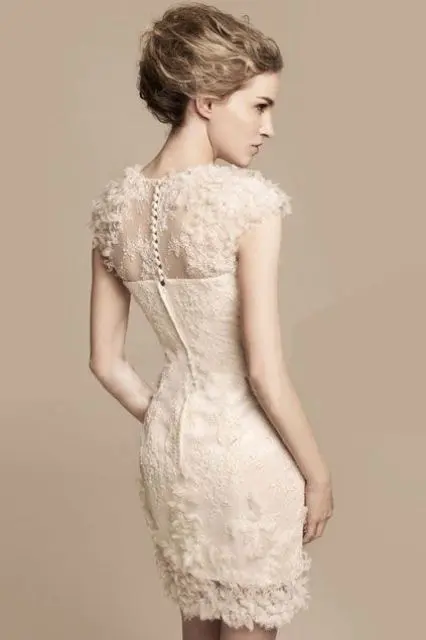 a romantic blush sheath short wedding dress of lace, with cap sleeves and feathers for a cute touch