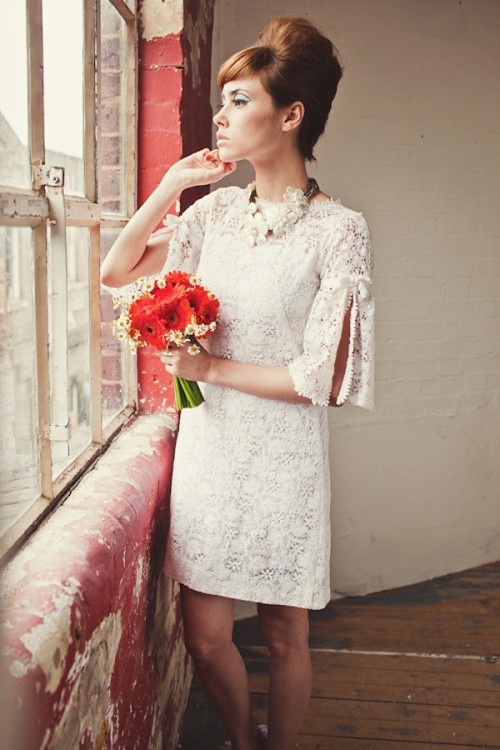 a short lace hippie-inspired wedding dress with bell sleeves with cuts and a high neckline is very cool and bold
