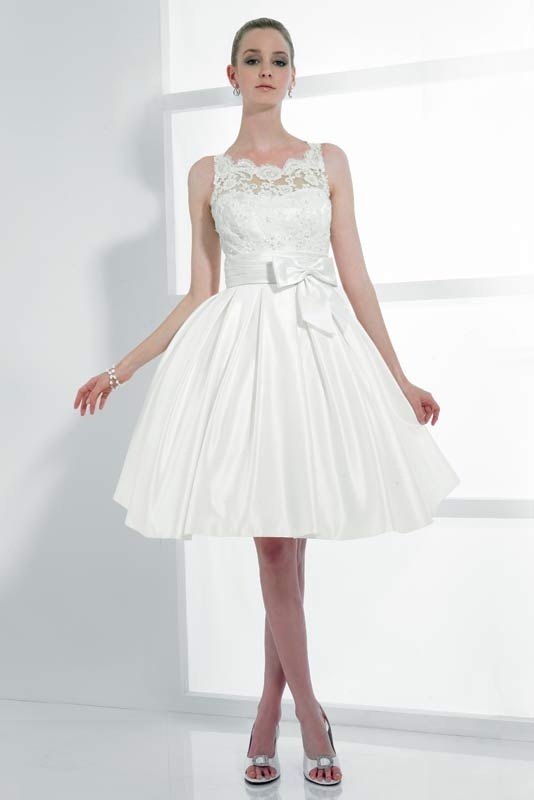 A vintage inspired A line wedding dress with a lace sleeveless bodice and a pleated full skirt with a bow