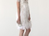 a short art deco wedding dress with an illusion embellished patterned neckline and a feathered skirt plus an embellished clutch and white shoes